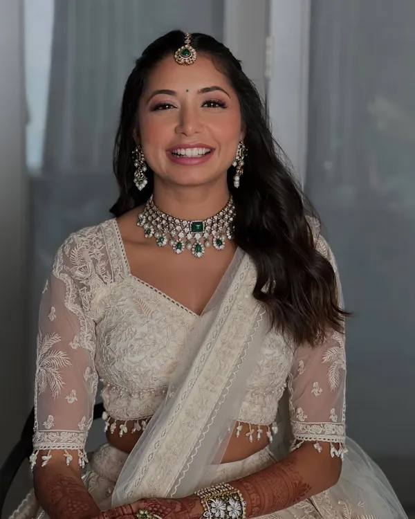 This is the essence of my work. A radiant bride with a genuine smile, her skin glowing and features beautifully enhanced. We went for a soft glam look with defined eyes and a natural lip color that perfectly complemented her elegant ivory lehenga.