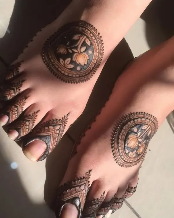 This unique foot design features a bold circular pattern on the top of the foot with detailed work on the toes. The dark fill creates a striking contrast.