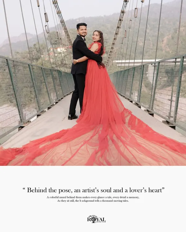A full-length shot of a couple on a suspension bridge, with the bride's magnificent red trail gown spread across the walkway. A perfect example of a grand, fairytale portrait.
