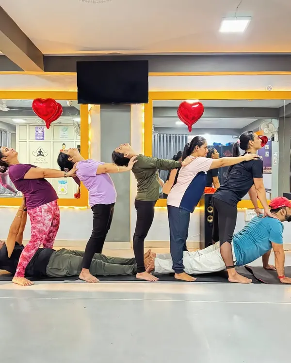 A human train created through a group yoga pose. This fun and challenging formation requires everyone to work together, symbolizing support and interconnectedness within a team.