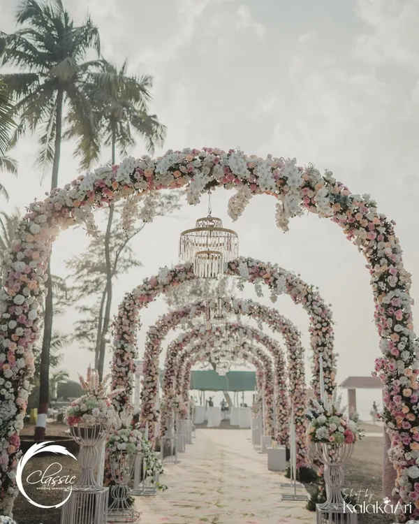 This is what I mean by making an entrance. I designed this breathtaking floral tunnel with cascading blooms and elegant chandeliers to create a truly magical pathway for the couple and their guests at a stunning resort wedding.
