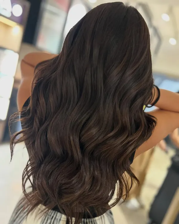 Hot chocolate season is here. This warm brown two-tone color features subtle peekaboo highlights that add dimension while maintaining an overall rich, dark look.