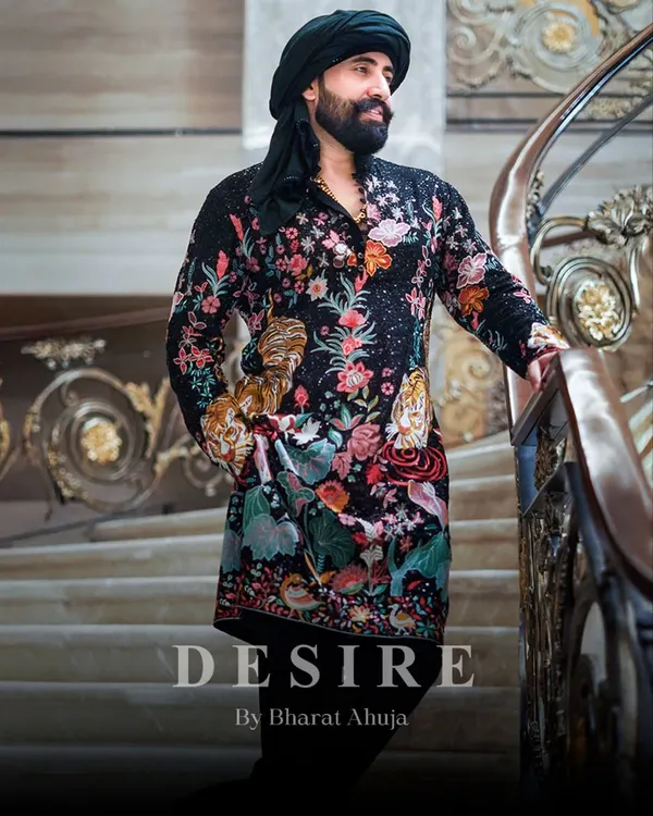 I believe clothing should tell a story. This black kurta is a canvas of intricate, multi-colored embroidery, featuring florals and tigers for a look that is pure royalty. The addition of a traditional turban completes this powerful statement.