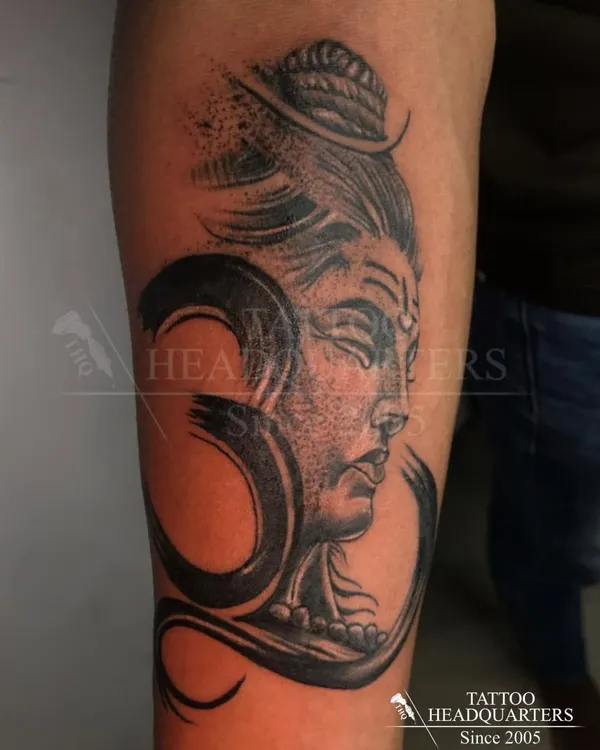 A powerful depiction of Lord Shiva combined with the sacred Om symbol. This black and grey realism tattoo captures a serene yet strong presence.