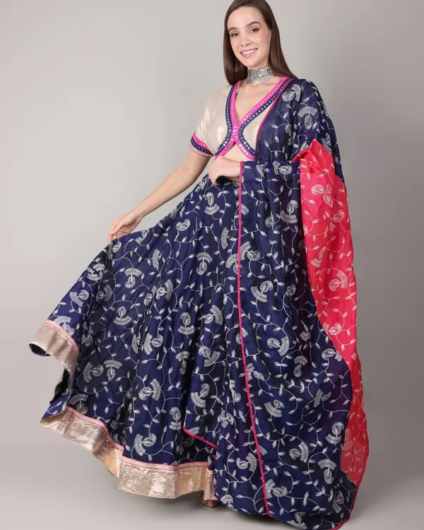 A model showcases the full twirl of this royal blue and pink Navratri lehenga. The lightweight fabric and comfortable fit are perfect for long nights of dancing Garba and Dandiya.