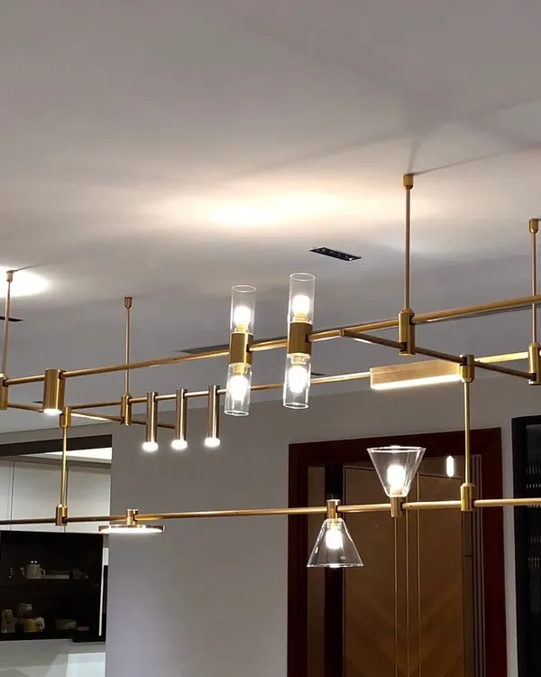 The MMDLS Chandelier is a playground for light. This image shows one possible configuration of the modular system, combining different shapes and sizes of light to create a dynamic, sculptural centerpiece over a dining area.
