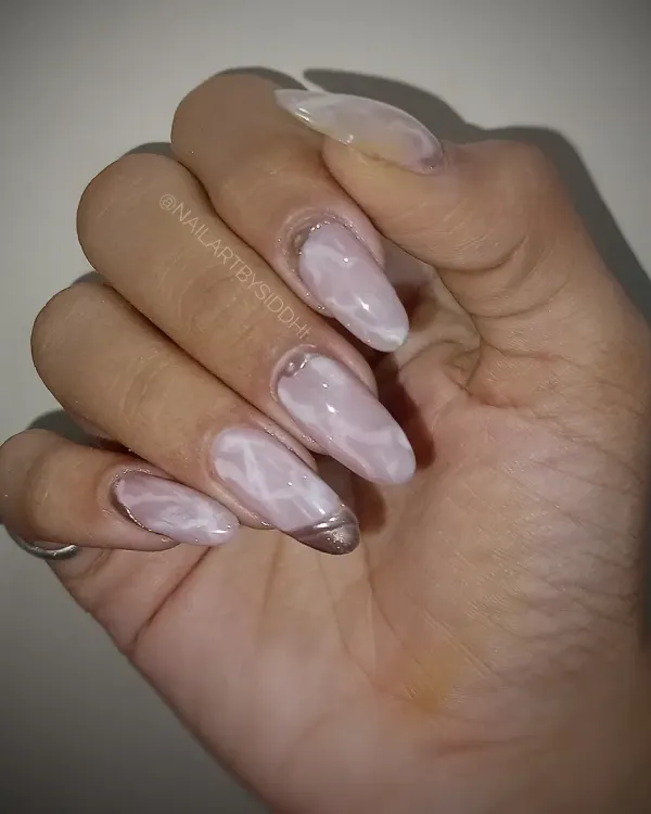 A beautiful example of a soft pink cat-eye effect, creating a marble-like shimmer on long almond nails.