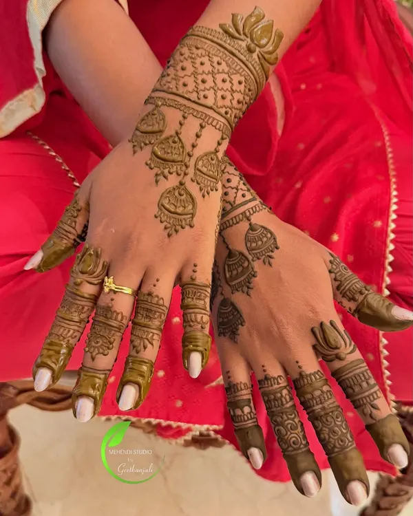 A beautiful and minimal design featuring hanging jhumka motifs on the back of the hands. This is a perfect choice for guests or for a simple, elegant look.