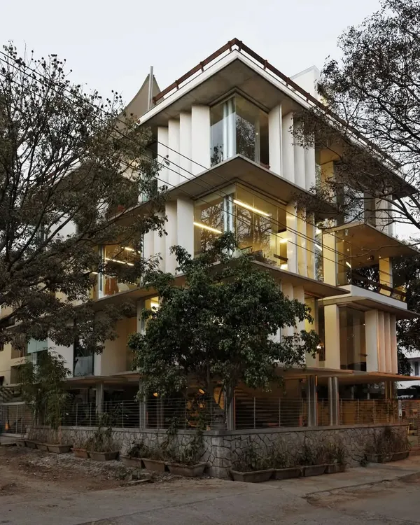 The Nirvana Films Studio in Bengaluru is designed to dissolve the boundaries between inside and out. The building's transparent facade and operable louvres allow the workspace to be immersed in the surrounding trees, creating a tranquil and inspiring atmosphere for a creative ad film company.