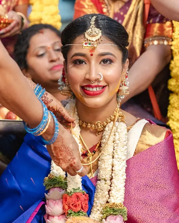 I believe a bride's true radiance shines through in the quiet moments. Here, amidst the beautiful chaos of a traditional Kannada wedding, her joyful smile says everything.