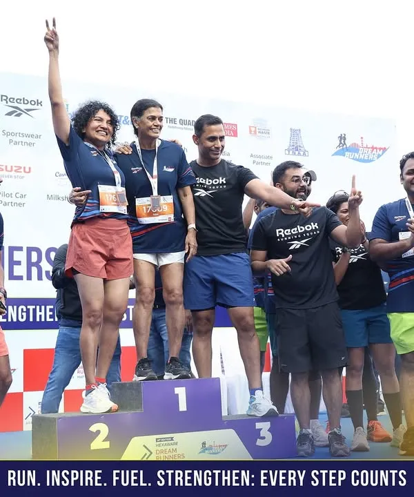 Celebrating a podium finish at the Dream Runners Half Marathon in Chennai. I'm on stage with our victorious runners, sharing in their success.