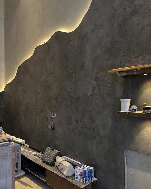 This is more than just a wall; it's a piece of art. We created this organic, flowing wave design with integrated LED backlighting in a micro-concrete finish, turning a simple surface into a dramatic focal point.