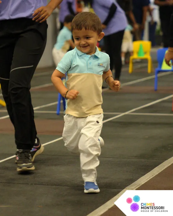 Pure joy in motion. A child runs with a huge smile during a race on Sports Day, embodying the fun and energy of the event.