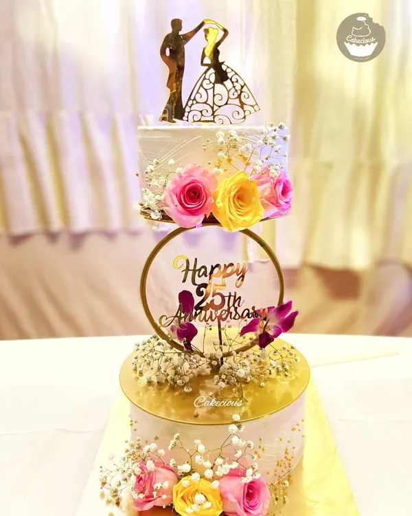 A beautiful two-tier cake to celebrate a 25th wedding anniversary. The design features a cascade of fresh flowers, combining elegance and romance for this silver jubilee.
