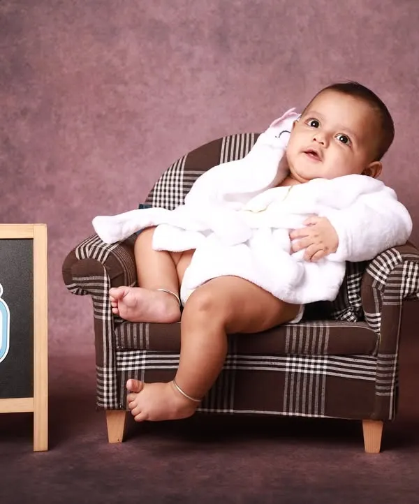 This half-birthday setup is all about personality. Here, the little one looks thoughtfully to the side, showing a calm and curious moment during this fun six-month milestone session.