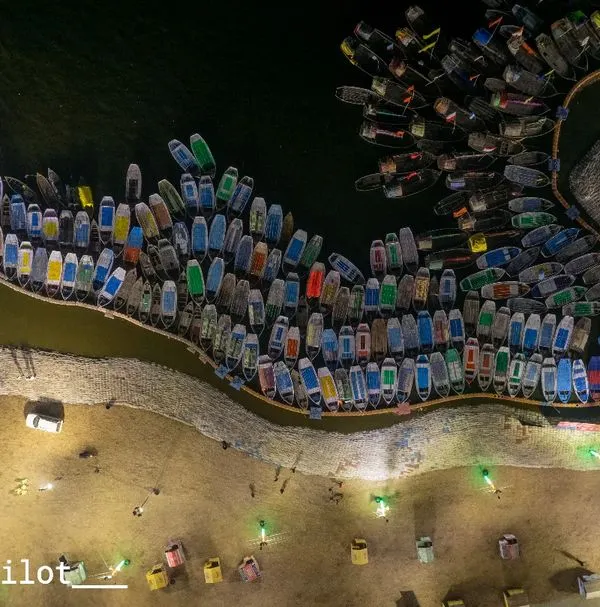 A top-down aerial view of the countless boats docked at Sangam, Prayagraj, glowing under the night lights. This is the kind of complex, beautiful scene I love to capture.