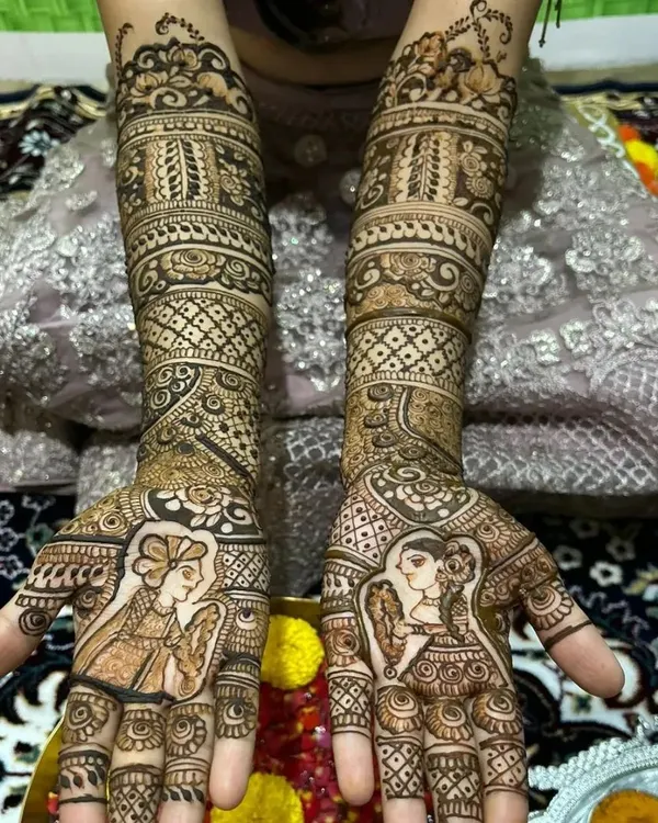 A full view of a classic bridal henna design. The portraits of the bride and groom on the palms are surrounded by traditional patterns and motifs that extend up the forearms.