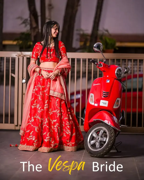 A modern bride with a twist. This playful and unique concept pairs a traditional red lehenga with a vintage red Vespa, creating a fun, memorable, and stylish bridal portrait.