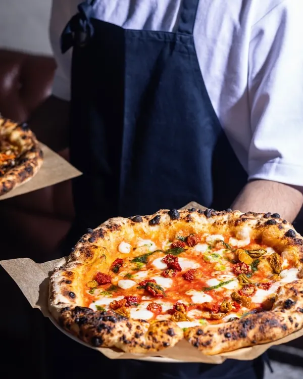 Double the pizzas, double the love. I’m here to make all your wood-fired cravings come true, serving up fresh pies that bring everyone to the table.