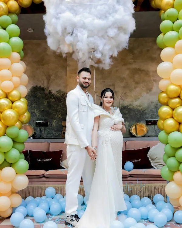 The happy couple after their exciting gender reveal. The floor covered in blue balloons captures the pure joy of the moment.