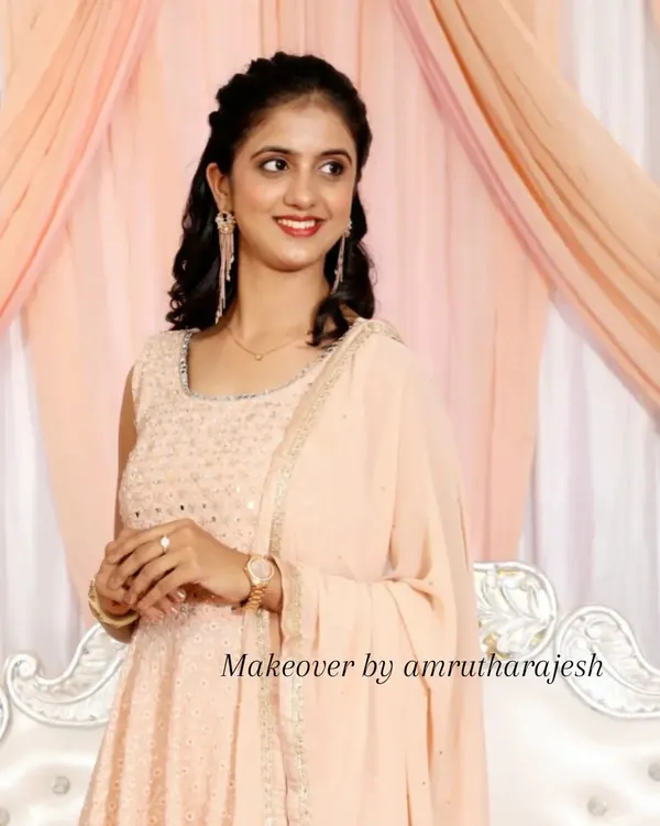 A soft and dreamy look for a reception. I styled her hair in gentle curls and used a peachy, monochromatic makeup palette to complement her beautiful pastel sharara.