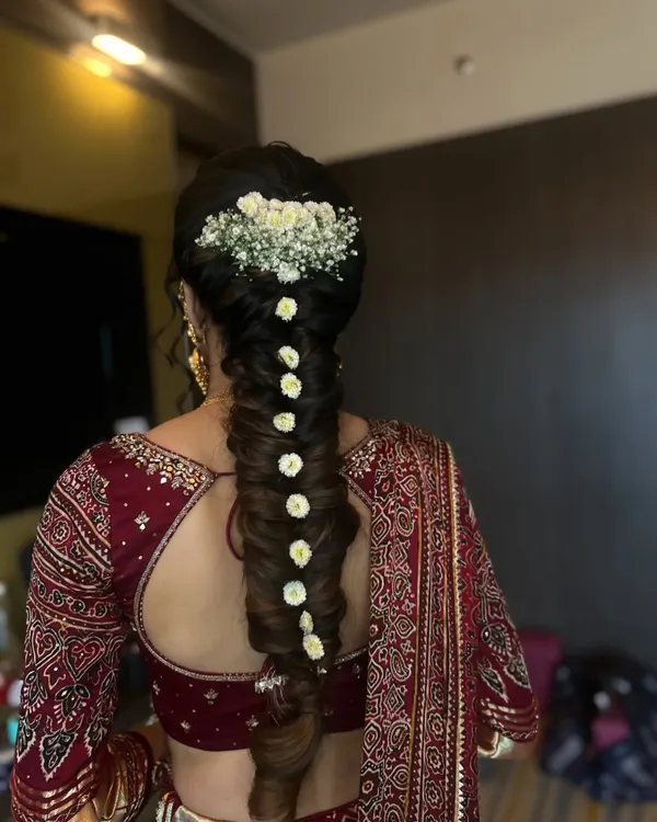 An elegant twisted braid for a Bhaat function, adorned with baby's breath and small white flowers. This style is both traditional and incredibly chic.