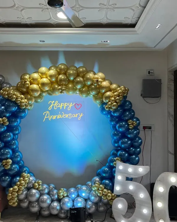 This is a grand backdrop I created for a 50th anniversary party. The large balloon ring in blue, gold, and silver, combined with light-up marquee numbers, makes for a perfect photo spot to celebrate a major milestone.