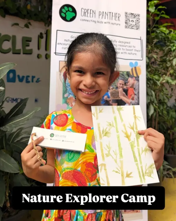 A happy explorer proudly showing off her bamboo painting and nature journal from our camp. Her smile says everything about the joy of creating with nature.