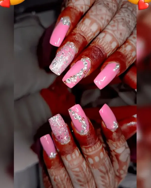 This is the ultimate bridal look. I created these long, square acrylic extensions with a vibrant pink, adding full silver glitter on the ring finger and delicate rhinestone patterns to complement her beautiful mehendi. It’s all about making you feel special on your big day.