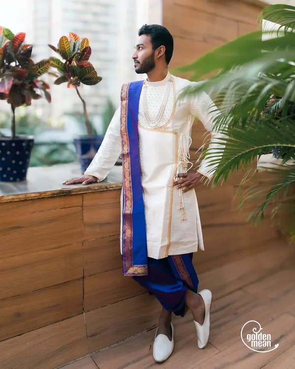 A stylish portrait of the groom in his traditional Maharashtrian attire, looking confidently into the distance.