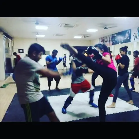 My kickboxing classes are high-energy and focus on practical application. Here, students are sparring to practice their striking and defensive skills in a safe, controlled setting.