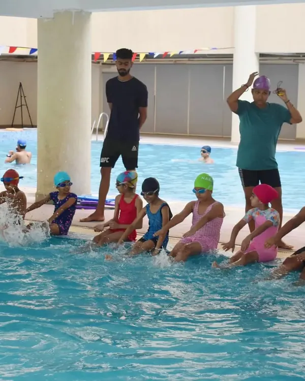 We start with the basics. Here, a group of young learners practices their kicking technique at the edge of the pool under the watchful eye of my coaches.