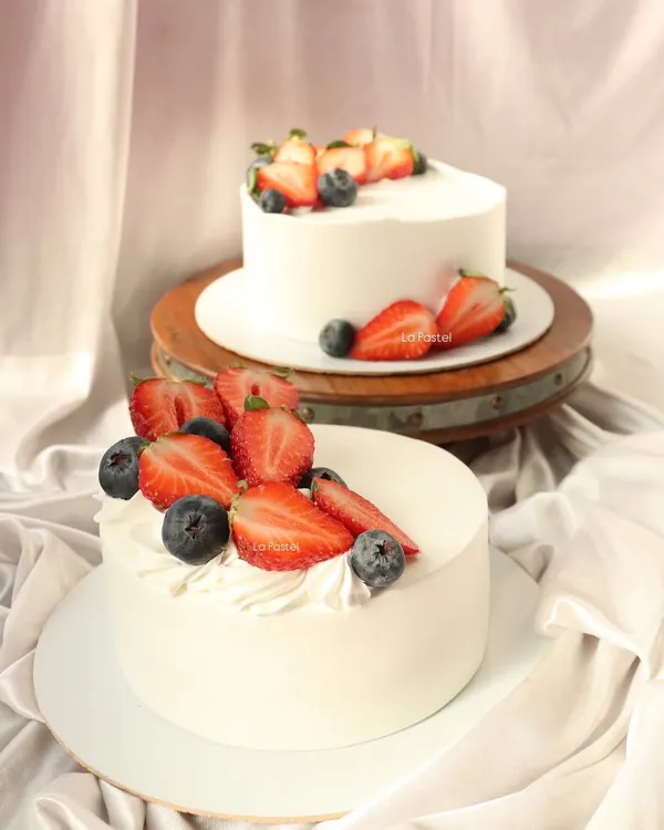 My classic fresh fruit cakes. These eggless vanilla cakes are topped with fresh strawberries and blueberries for a simple, elegant dessert.