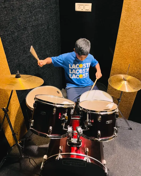 A young drummer in action, fully engaged in his lesson. Our drum classes in HSR Layout are designed to be fun, energetic, and skill-building.