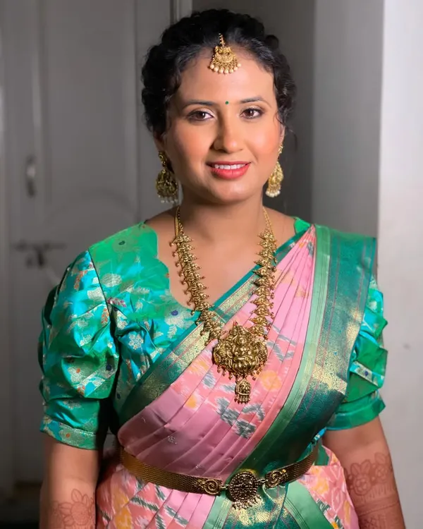 Swathi looking lovely for her sister's reception. This is a great example of a non-bridal look that is still elegant and photo-ready, featuring a pink and green saree and traditional jewelry.