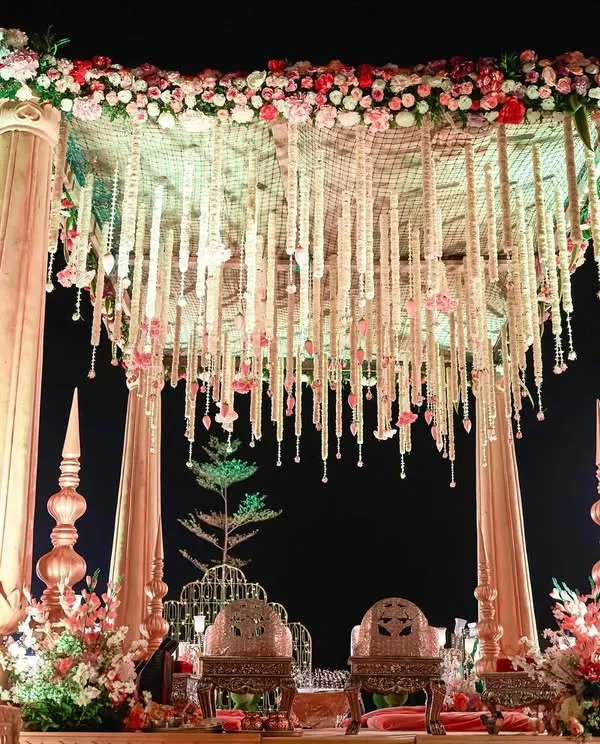 This is what I call tying the knot in style. A larger-than-life mandap with grand pillars and a canopy of hanging floral strings creates a truly royal and unforgettable setting for the wedding ceremony.