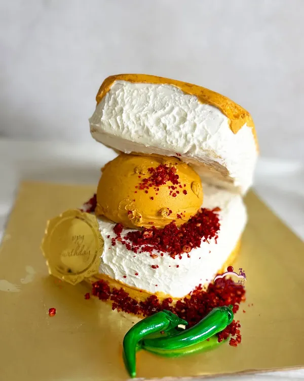 A cake for a true Mumbaikar! This is a Vada Pav cake, complete with the "vada" (a cake ball), "chutney" (colored crumbs), and even sugar-paste chillies. It was a butterscotch praline cake inside.