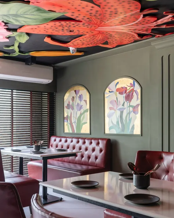 Inspired by Michelangelo but with a modern, juicy twist, this ceiling mural brings a garden indoors. Oversized lilies and pomegranates create a dramatic fresco, proving that ceilings deserve as much attention as the plates below.