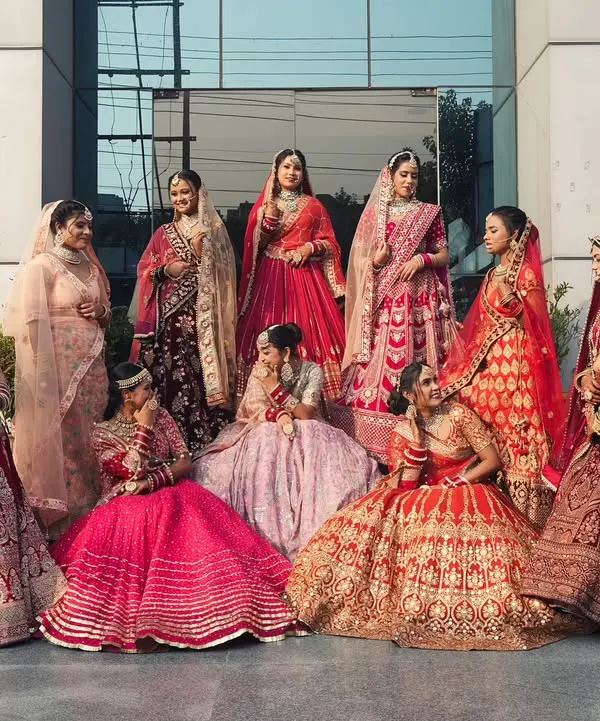 A beautiful showcase of our students' work on exam day. This group photo highlights the variety of bridal lehengas, makeup styles, and hair designs they mastered during their course, from vibrant reds to soft pinks.