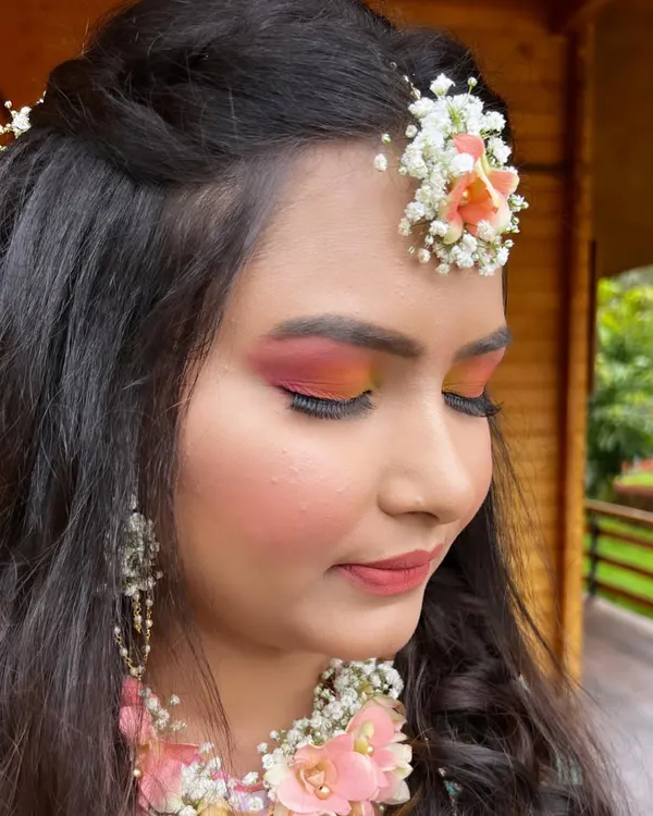 A close-up of the colorful eye makeup for this bride's Haldi ceremony. I used hues of pink and orange to match her outfit and floral jewellery, creating a look that's both pretty and playful.