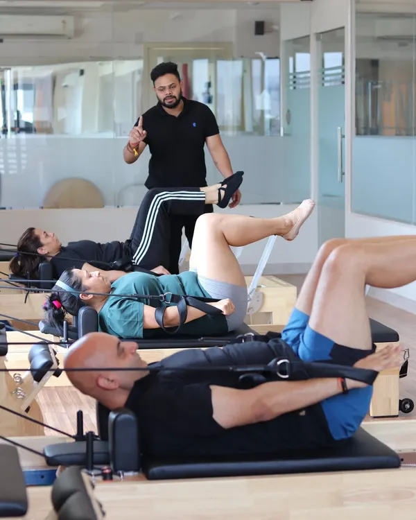 An instructor provides precise guidance during a small group class. This personalized approach ensures everyone is moving safely and effectively, which is the cornerstone of our pain management and recovery programs.