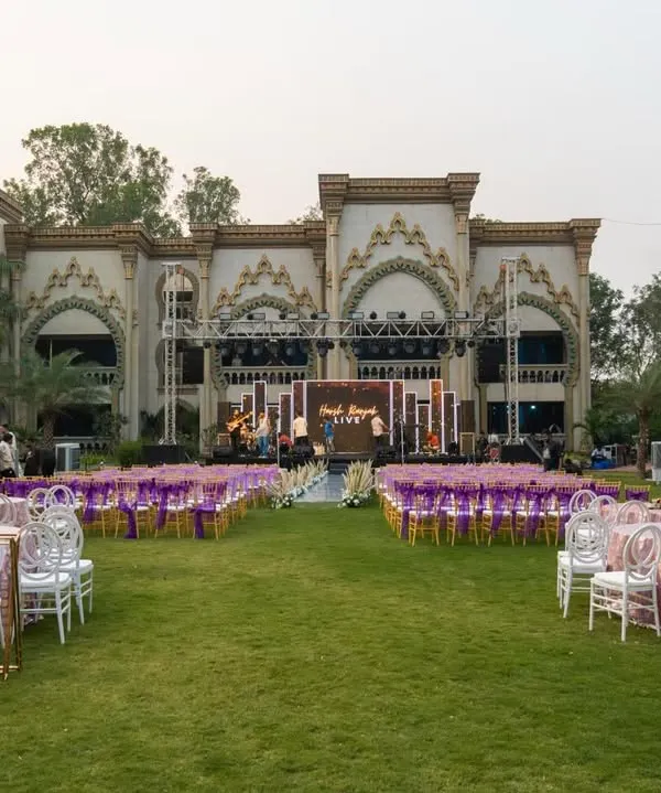 A wide angle view of a stunning 25th anniversary celebration I produced. The event featured a large concert style stage, elegant round table seating for dinner, and a separate gallery seating area, all set against the backdrop of a beautiful estate.