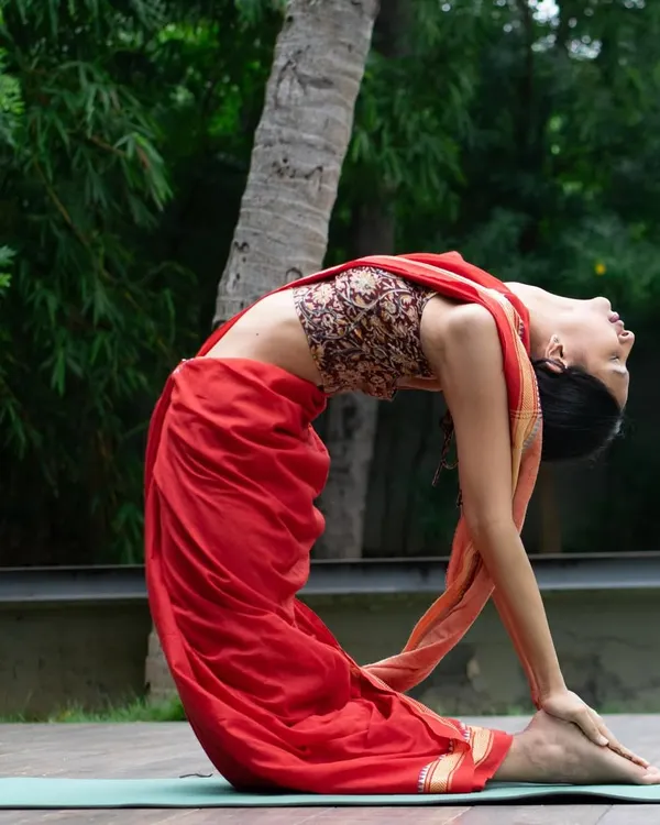 This is the Ustrasana, or Camel Pose, a deep backbend that opens up the chest and improves spinal flexibility. I love how practicing yoga in a saree connects me to my roots while I flow.