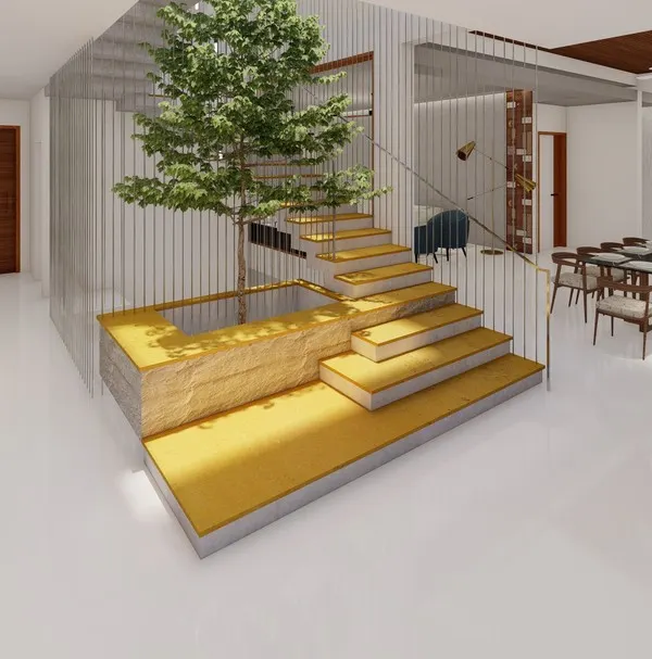 A double-height courtyard is the centerpiece of this home, featuring a staircase that appears to float over a Jaisalmer yellow stone base. A living tree grows within the space, reaching towards the skylight above.