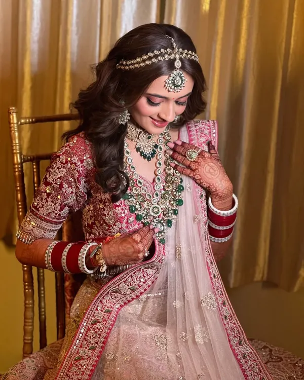 This bride's soft girl look is pure perfection. The makeup is minimal and dewy, with a focus on glowing skin and soft pink tones to complement her pastel lehenga.