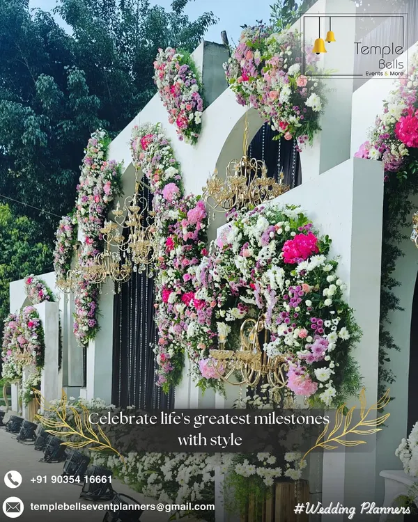 An opulent floral facade we created for a luxury wedding event. This design features cascading bouquets of pink and white flowers accented with golden chandeliers, transforming a simple wall into a breathtaking photo opportunity.