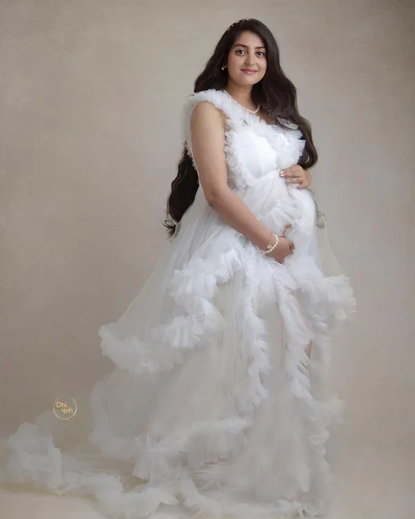 This full-length portrait in a flowing white ruffled gown creates such an angelic and ethereal feel. In the studio, we can play with fabrics and poses to create fine-art maternity images that look like they belong in a gallery.