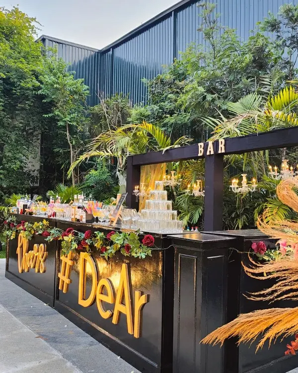 Our elegant black bar setup, decorated with florals and a custom hashtag, is perfect for sophisticated outdoor weddings and receptions. It provides a chic and personalized focal point for your guests.