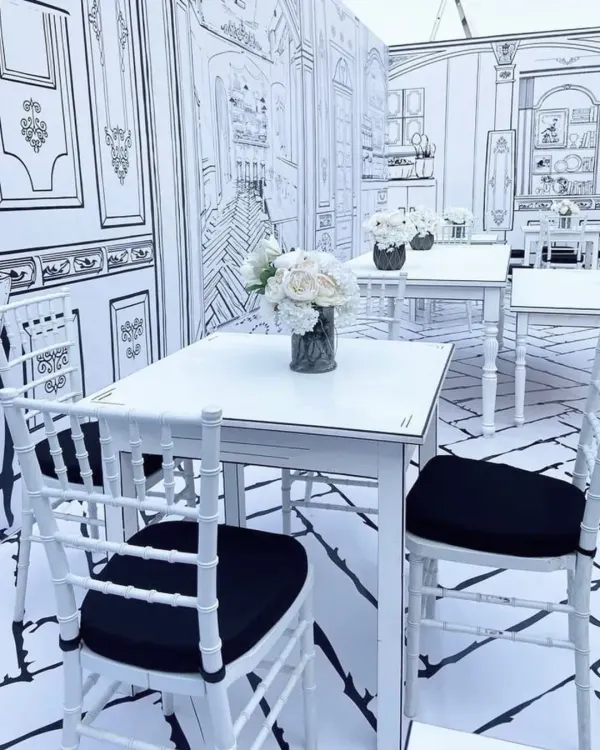 A closer view of the 2D cafe theme, where even the tables and chairs are outlined in black to create a surreal, hand-drawn effect.