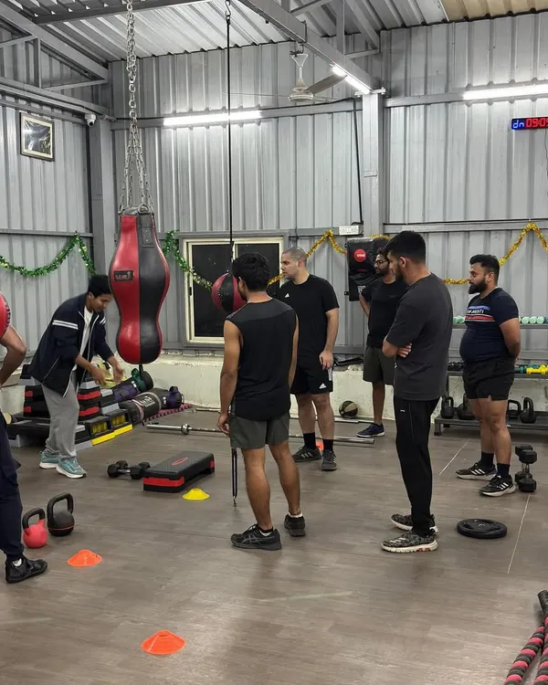 Every session starts with a clear briefing. Here, a senior trainer demonstrates the exercises for the day's circuit, ensuring everyone understands the movement and its purpose before we begin.